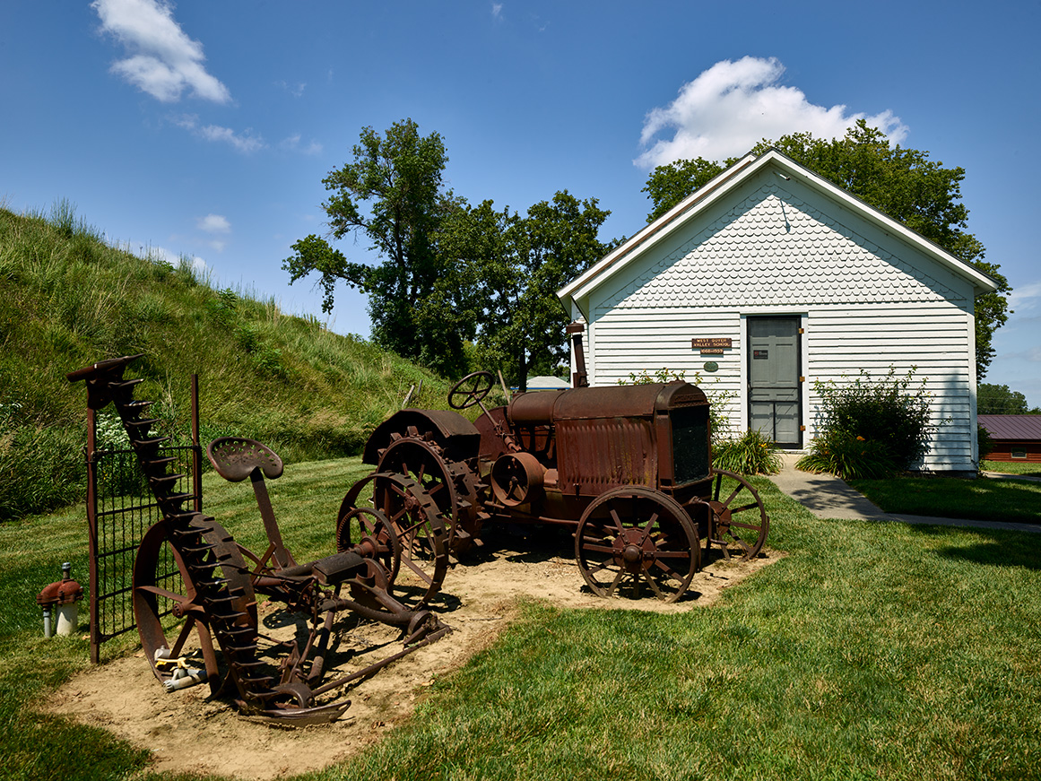Rusted old farm equipment stands outside the one-room West Boyer Valley schoolhouse at the Harrison County Historical Village and Iowa Welcome Center, outside the town of Missouri Valley on U.S. Highway 30, the historic Lincoln Highway that crosses the natio